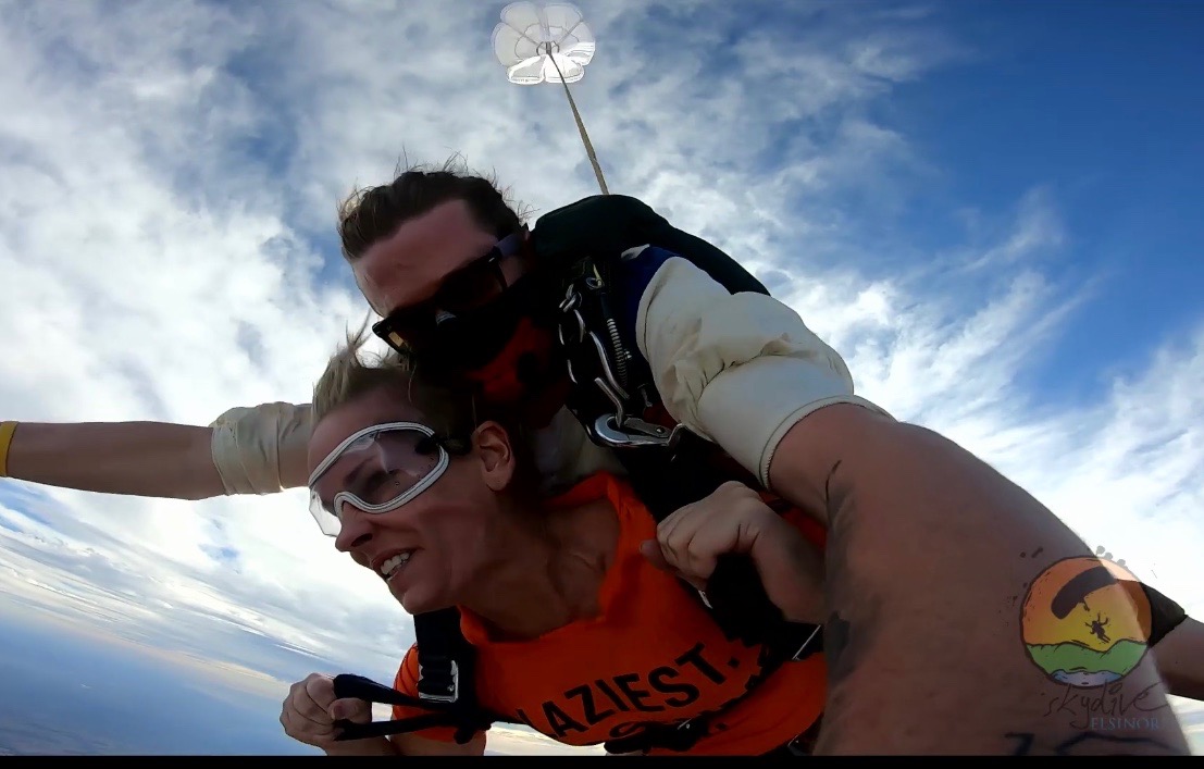 Suzanne parachuting from a plane in tandem with her Instructor.