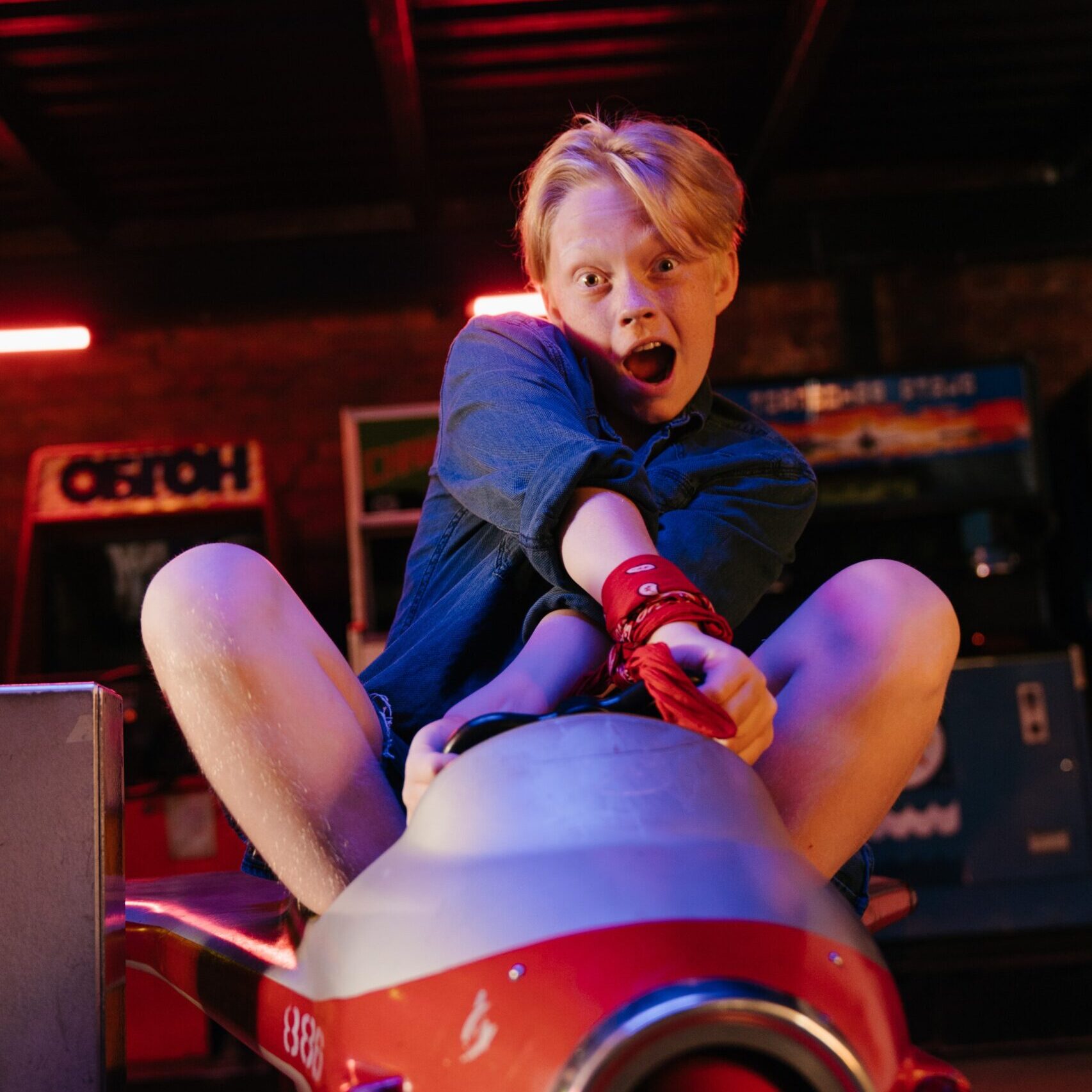 A young teen who is riding in an airplane inside an amusement and game store.