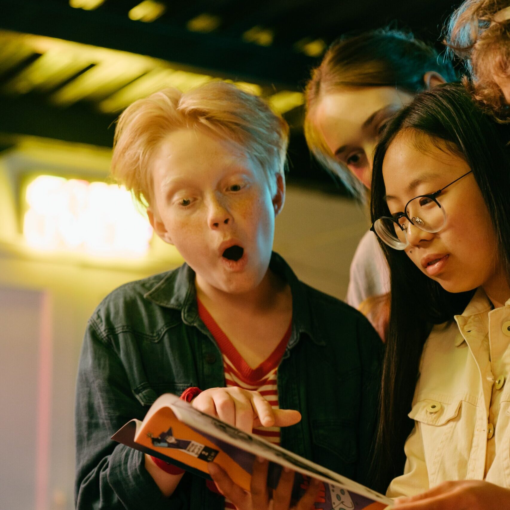 Children looking in amazement at a magazine that has caught their attention.